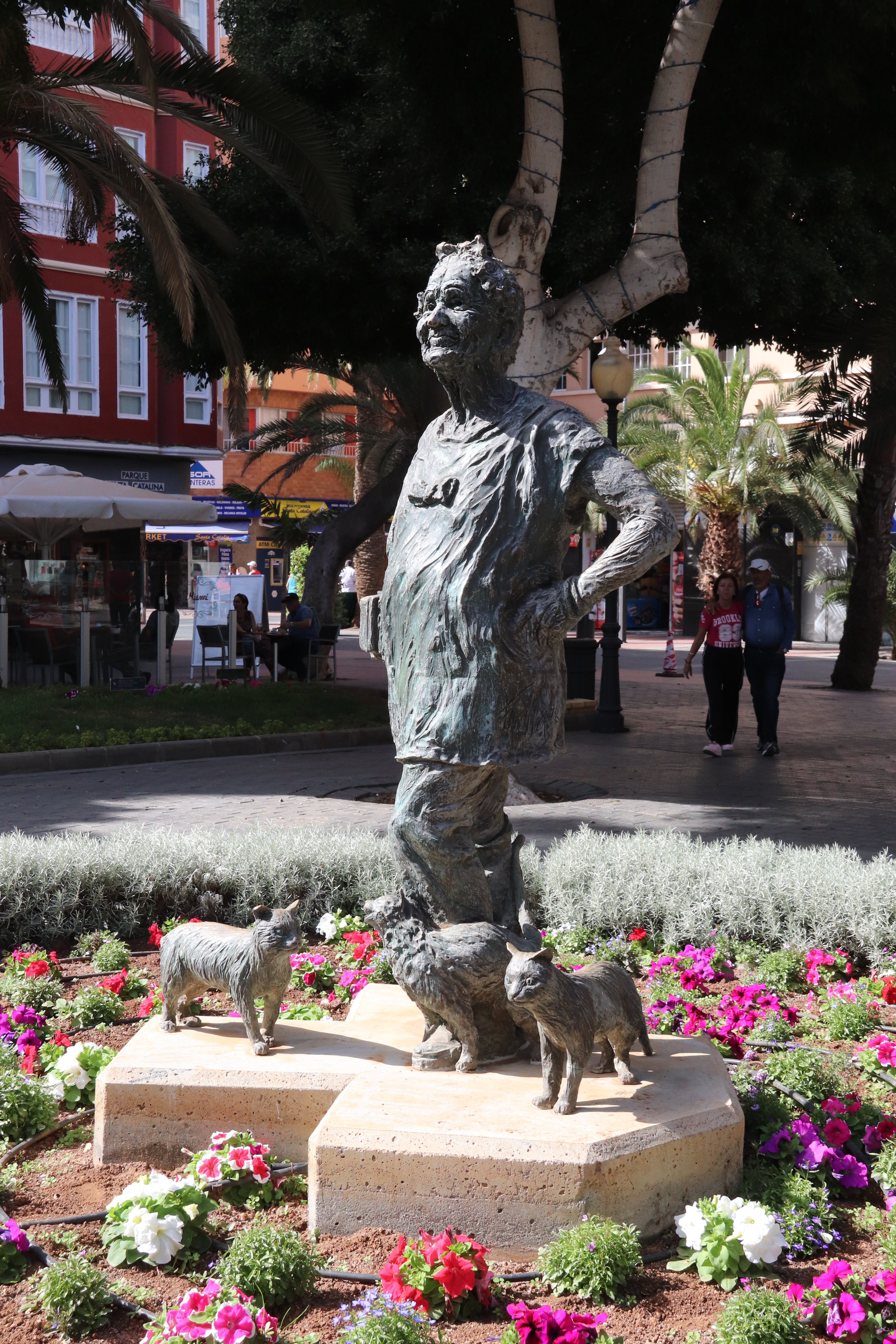 a bronze statue of Lolita Plume, an old lady surrounded by cats. 
