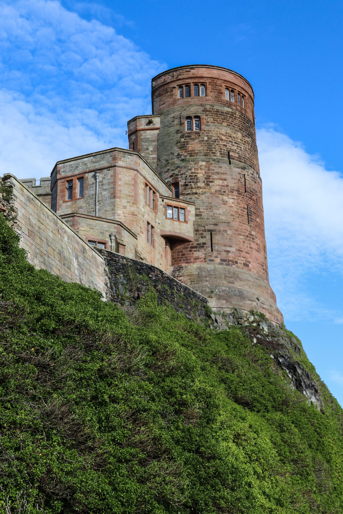 A turret of Bamburgh castle against bright blue skies. 