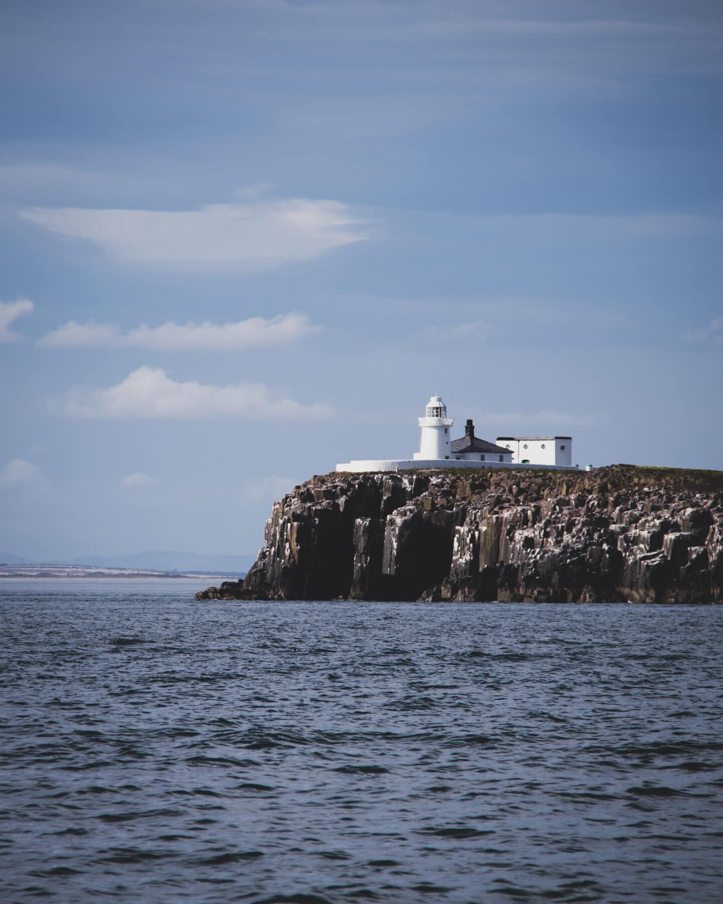 A view of the Inner Farne light house which is entirely white. 