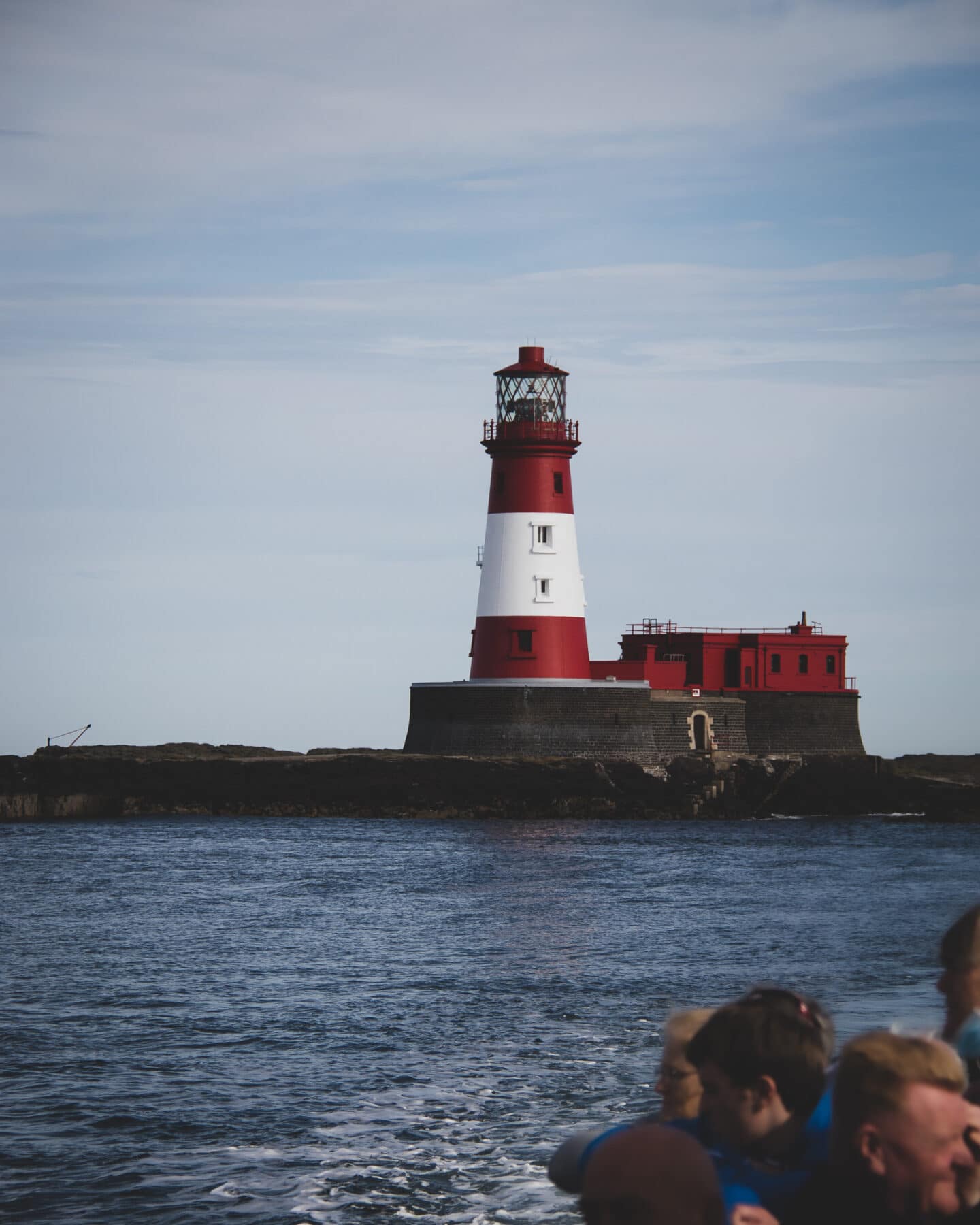 A view of Longstone Lighthouse from our boat. The lighthouse is red with a whitestripe around the middle. 